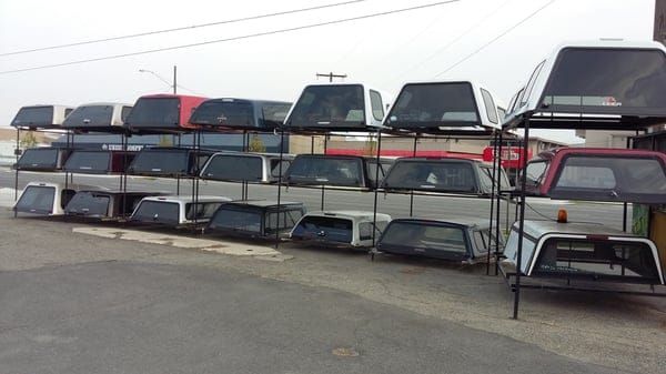 Racked truck toppers outside the shop
