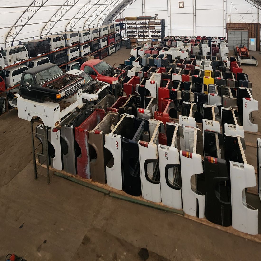 Inside the warehouse — rows of truck boxes and cabs